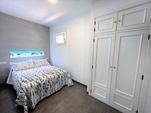 a small bedroom with a bed and a closet at Atico la cascada de conil in Conil de la Frontera