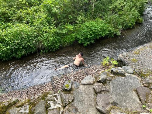 a man laying in the water in a river at Villa Noël Kitakaruizawa Seiryu Sauna & Open Air Bath in Tsumagoi