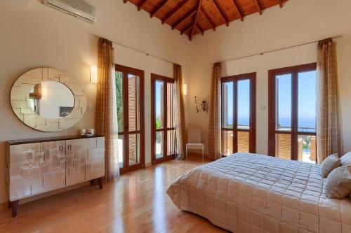 a bedroom with a bed and a mirror and windows at Aphrodite Hills Elite Villas Elite Superior Villa 0266 Private Pool 3 Bedrooms Paphos in Paphos