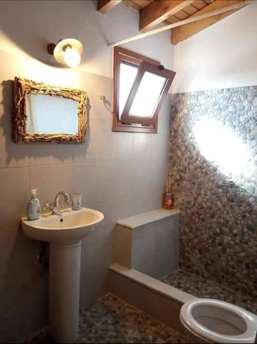 a bathroom with a sink and a toilet and a window at dilemi 3 in Tavari
