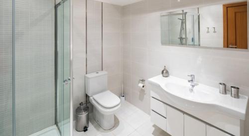 a bathroom with a toilet and a sink and a shower at Villa Povo Do Burro, Beautiful And Elegant Villa, Few Minutes Walk To Resort in Carvoeiro