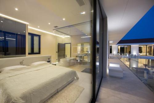 a bedroom with a large bed and a balcony at Stunning Seafront House In Istria Villa Vrsar Magnifique Contemporary 5 Bedroom Villa Sauna And Gym Direct Access To Sea in Vrsar