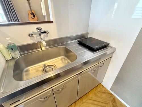 a kitchen sink with a tablet on top of it at TABISAI HOTEL Premium 博多-中洲 in Fukuoka