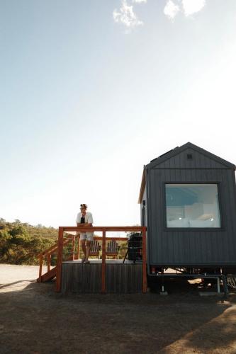 a person standing on the deck of a tiny house at Tiny Rosie in Mount Crawford