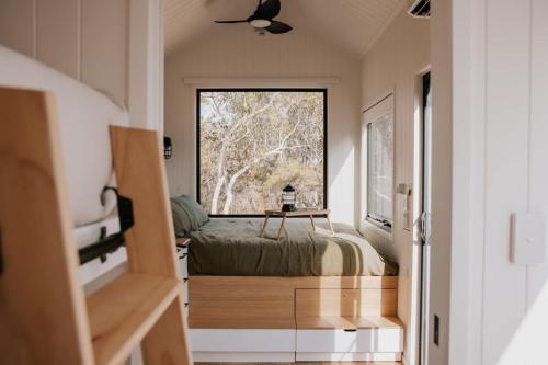 a small bedroom with a bed and a window at Tiny Wombat and Wallaby in Dural