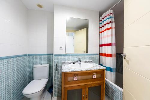 une salle de bain avec toilettes, lavabo et miroir dans l'établissement Apartamento increible Playazo Vera, à Vera
