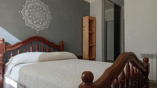 een slaapkamer met een houten bed en een spiegel bij Exelente departamento en Carlos Paz in Villa Carlos Paz