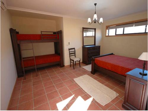 a bedroom with two bunk beds and a chair at Beautifully Restored Ponte De Lima Farm House 6 Bedrooms Quinta Fornelos Private Pool & Surrounded By Hectares Of Vineyards in Ponte de Lima
