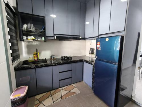 a kitchen with black and white cabinets and a blue refrigerator at Little LN Homestay KLIA in Banting