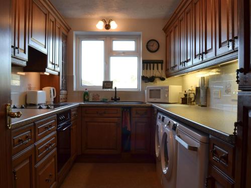 eine große Küche mit Holzschränken und einem Fenster in der Unterkunft The Flat in Eaton