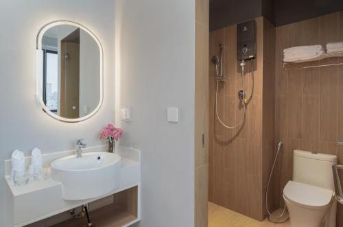 a bathroom with a sink and a toilet and a mirror at Emerald Hotel Residence in Phnom Penh