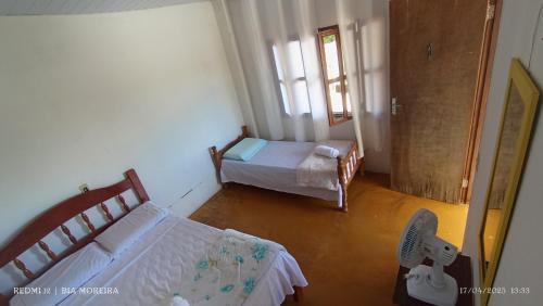 a small room with two beds and a window at Império hospedagem in Sao Jorge