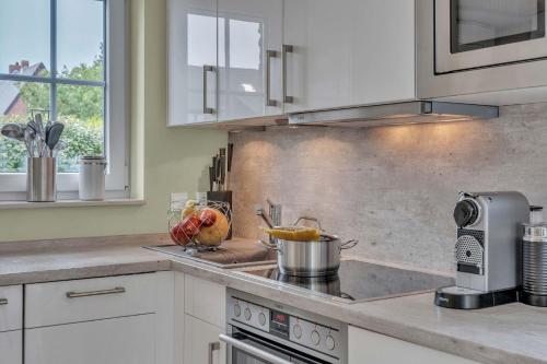 a kitchen with a stove with a pot on the counter at Haus-Alster in Westerland (Sylt)