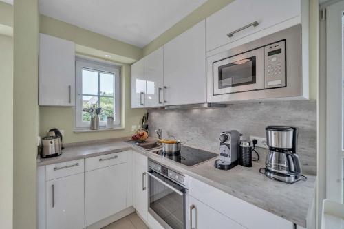 a kitchen with white cabinets and a counter top at Haus-Alster in Westerland (Sylt)