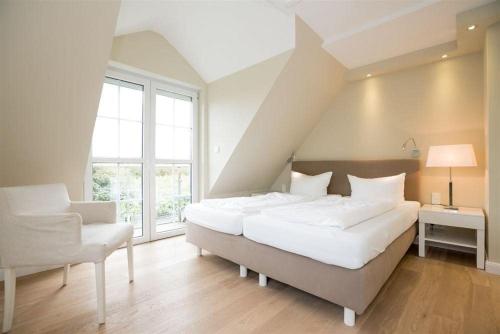 a large bedroom with a large bed and a chair at Haus-Alster in Westerland (Sylt)