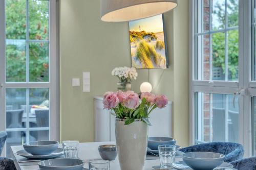 a vase of pink flowers sitting on a table at Haus-Alster-2 in Westerland (Sylt)