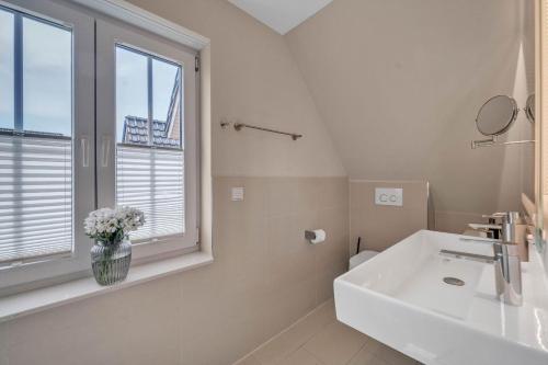 a white bathroom with a sink and a window at Haus-Alster-2 in Westerland (Sylt)