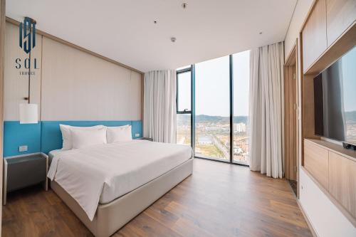 a hotel room with a bed and a large window at À La Carte Homestay By Sol Travel in Kon Rung (1)