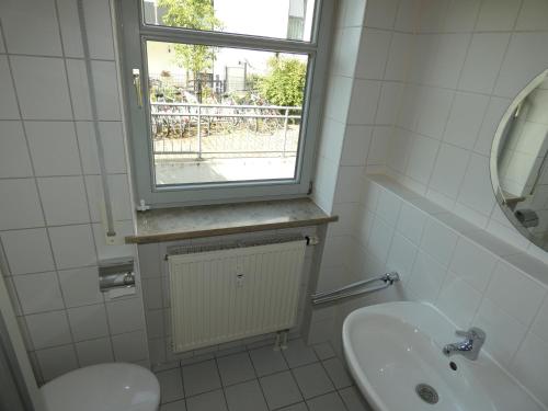 a bathroom with a sink and a window at WuP Living Apartment am Stadtwald TG Parkplatz in Augsburg