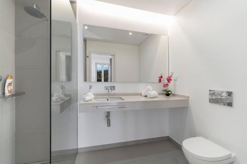 a bathroom with a sink and a toilet and a mirror at Luxury Calheta Villa Casa Calheta Heights 3 Bedrooms Stunning Sea Views in Calheta