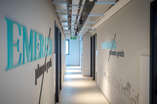 a hallway in an office building with signs on the walls at Emerald Hotel Residence in Phnom Penh
