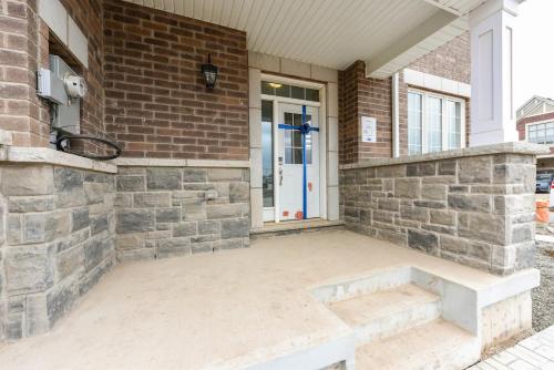 a front porch of a brick building with a bench at Spacious 4br25ba Retreat W King Beds, Desk, Dt in Milton
