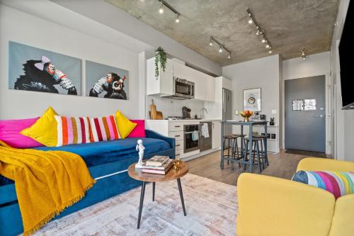 a living room with a blue couch and yellow chairs at Vibrant PopArt downtown suite, comfy and stylish! in Calgary