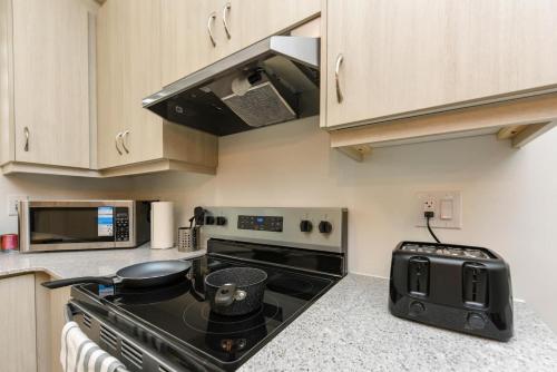 a kitchen with a black stove and a microwave at Spacious 4br25ba Retreat W King Beds, Desk, Dt in Milton