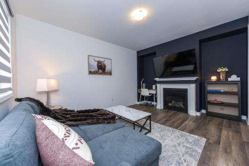 a living room with a blue couch and a fireplace at Spacious 4br25ba Retreat W King Beds, Desk, Dt in Milton