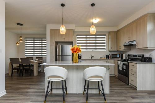 a kitchen with white chairs and a kitchen island with a counter at Spacious 4br25ba Retreat W King Beds, Desk, Dt in Milton