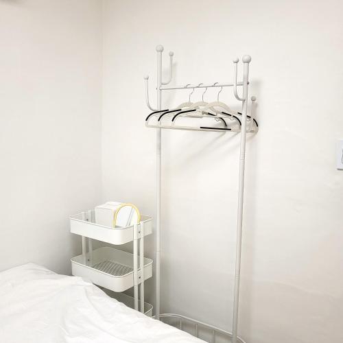 a white bedroom with a white bed and a shelf at Humming stay in Seoul
