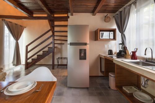 a kitchen with a refrigerator and a sink at Quinta Margarita - Boho Chic Hotel in Playa del Carmen