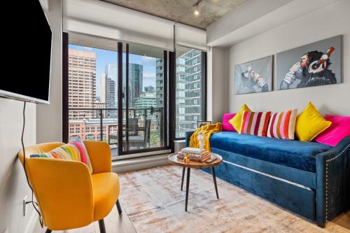 a living room with a blue couch and a window at Vibrant PopArt downtown suite, comfy and stylish! in Calgary