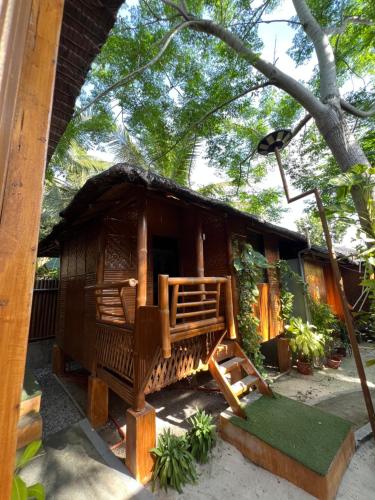 a small house with a thatched roof at L Cafe Restobar & Lyn's Guest House in San Juan