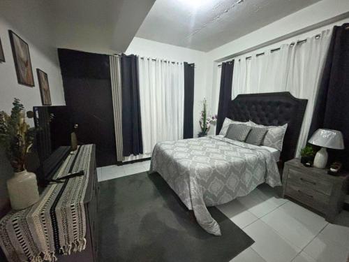 a bedroom with a bed and a bench in it at Villa Solara Your Spacious, Central, Affordable Stay in Kingston in Kingston