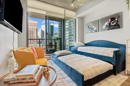 a bedroom with two beds and a large window at Vibrant PopArt downtown suite, comfy and stylish! in Calgary
