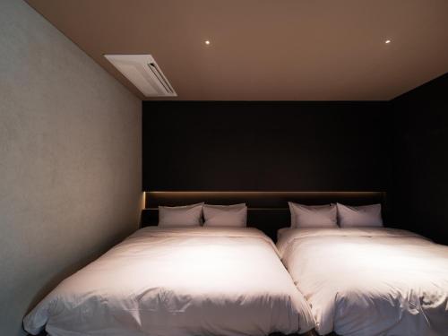 two beds sitting next to each other in a room at The Moor in Busan