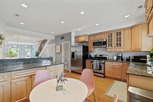 una cucina con mobili in legno e tavolo bianco di Central DC Retreat Luxury In-Law Suite 3BR & 3 BA #DCottage a Washington