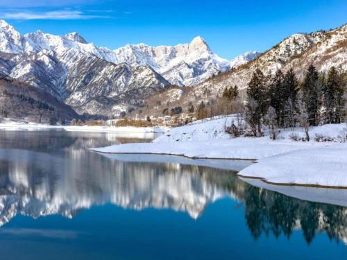 a view of a lake with snow covered mountains at Retreat in the Dolomites in Chies dʼAlpago