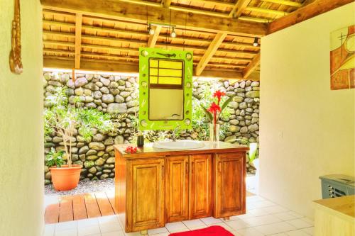 a bathroom with a sink and a mirror at TAHITI Tamanu House - Séjour Bord de mer, Plage privée, TV, Wifi, Hôte Polynésienne in Papehee
