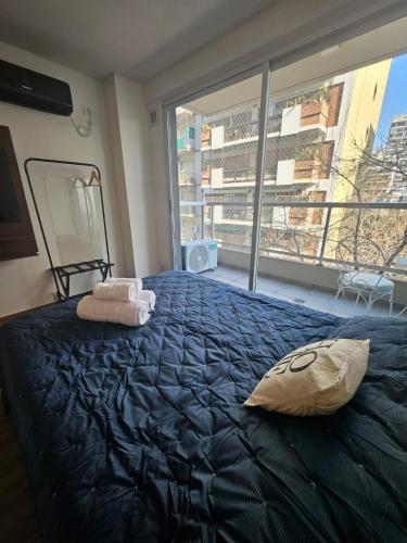 a bedroom with a large bed and a large window at Cómodo y moderno departamento en Buenos Aires in Buenos Aires