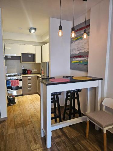 a kitchen with a island in the middle of a room at Cómodo y moderno departamento en Buenos Aires in Buenos Aires