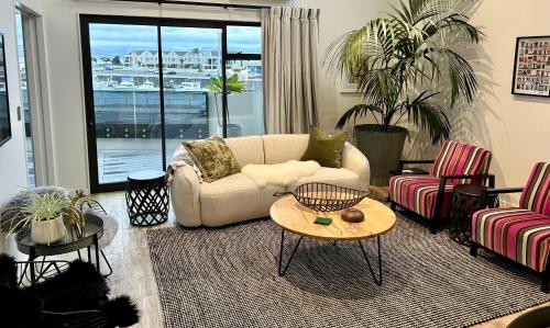 a living room with a couch and a table at SEAduction Luxury Apartment in Napier