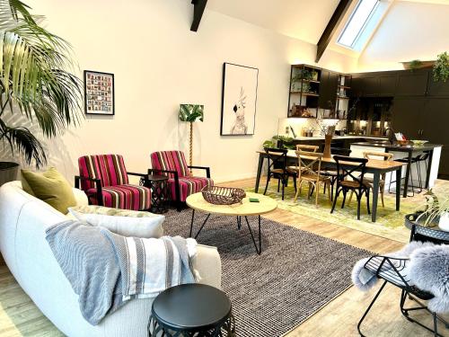 a living room with a couch and chairs and a table at SEAduction Luxury Apartment in Napier