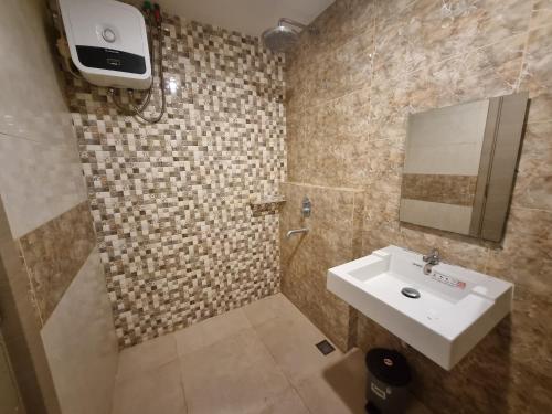 a bathroom with a sink and a mirror at Studio Room Apartment with Pool in Yogyakarta