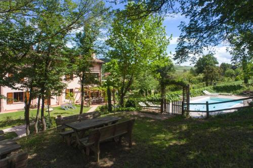 un parque con banco y piscina en Agriturismo Il Cavicchio, en Pianoro