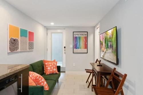 a living room with a green couch and a table at Cozy Mid-Century Apartment Steps From Restaurants #DCottage in Washington