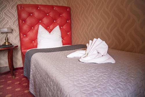 a hotel room with a bed with white towels on it at Wellness Hotel Beethoven in Chomutov