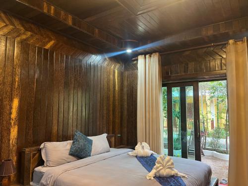 a bedroom with a bed with wooden walls at NanaSky Kampot Residence 