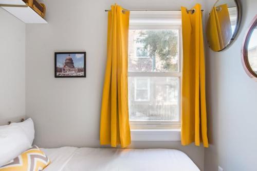 a bedroom with yellow curtains and a window at Mid-Century Marvel Steps from Restaurants Bars and Markets 3BR & 2BA in Washington